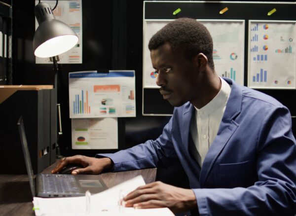 Detective inspector works in office, analyzing forensic evidence and conducts detailed background checks. Police officer identifying illegal activity, and gathering crucial information. Zoom-in shot.