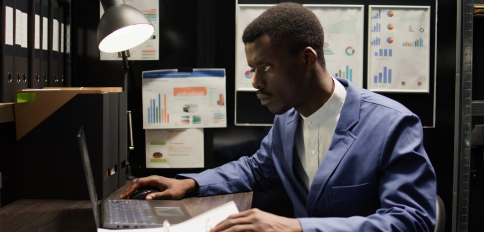 Detective inspector works in office, analyzing forensic evidence and conducts detailed background checks. Police officer identifying illegal activity, and gathering crucial information. Zoom-in shot.